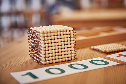 1000er Würfel aus Holzperlen und eine 1000 auf Papier