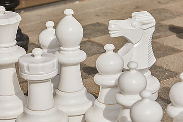 Weiße Figuren auf einem Outdoorschachfeld