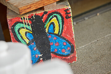 Gemalter, bunter Schmetterling auf einem Stein